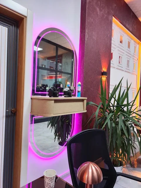 Showroom içi: bordo duvar, ışıklı aynalar ve dresuar örnekleri